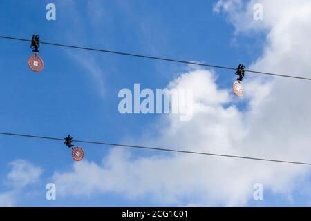 Tre deflettori circolari riflettenti luminosi a cielo aperto fissati a linee elettriche su uno sfondo blu a cielo aperto per proteggere gli uccelli. Foto Stock