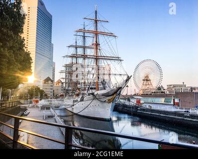 Yokohama, Giappone - Marzo 2018: La nave Nippon Maru attraccata con una ruota panoramica sullo sfondo Foto Stock