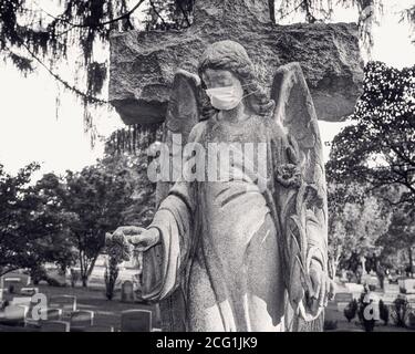 Statua dell'angelo del cimitero che indossa una maschera chirurgica Foto Stock