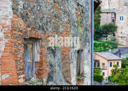 Vecchia finestra intemperie su un muro di mattoni in un villaggio Foto Stock
