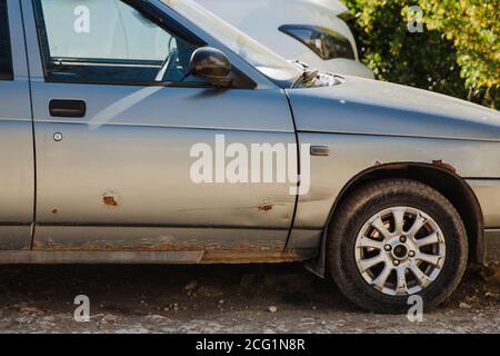 Porta auto e parafango auto con ruggine pesante. Necessita di riparazione, danni causati dal sale stradale. Foto Stock