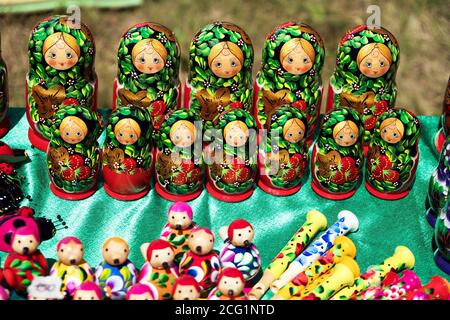 Vivaci souvenir tradizionali matryoshka bambole di fatto a mano stand insieme sul tavolo con altri giocattoli in legno. Foto Stock