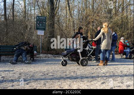 20.03.2015, Monaco, Baviera, Germania, Europa - in una giornata di sole primavera i genitori insieme ai loro bambini visitano un parco giochi pubblico nel Giardino Inglese. Foto Stock