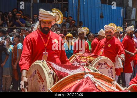 Pune, India - 4 settembre 2017: Membro di Ramanbaug Yuva Manvh, Dhol Tasha Pathak guardò direttamente nella macchina fotografica. Gioco dhol circondato da una folla Foto Stock