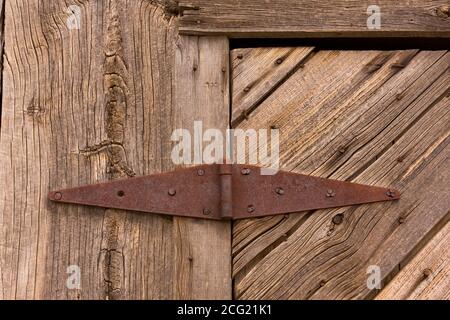 Cerniera arrugginita sulla porta di legno intemperie di un edificio derelitto nella città fantasma virtuale di Thompson Springs, Utah Foto Stock