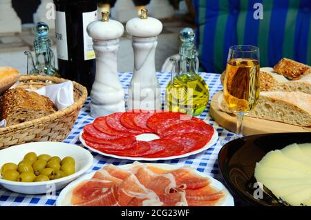 Selezione di tapas tra cui prosciutto crudo, salame, olvies verdi e formaggio Manchego, Calahonda, Spagna. Foto Stock