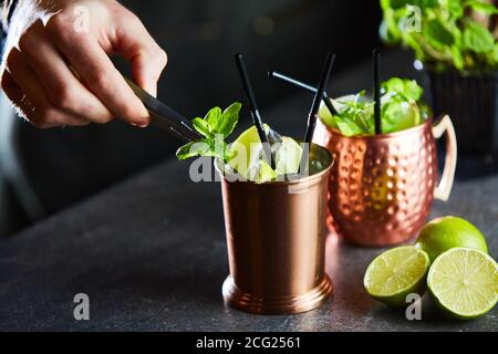 Cuba Libre, Rum e Cola drink con lime in tazze di rame in un bar Foto Stock