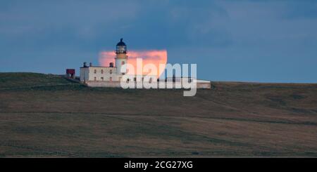 Luna piena che sorge dietro il faro di Copinsay, Orkney Isles Foto Stock