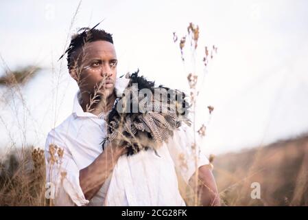 signore africano nel cespuglio africano con cappello bush dentro l'erba Foto Stock