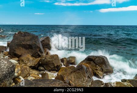 Le onde di mare rotolano sulla costa di pietra. Costa meridionale di Crimea Foto Stock