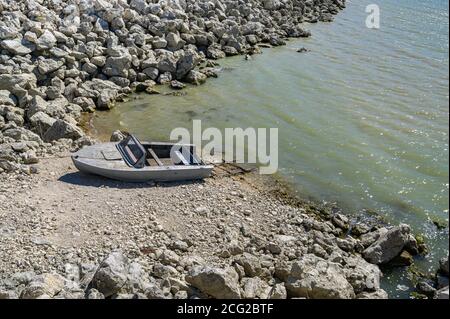 Imbarcazione a motore vuota per la pesca in metallo a riva Foto Stock