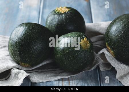 Zucchine rotonde mature su un asciugamano da cucina. Raccolta di verdure Foto Stock