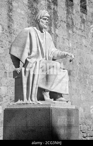 CORDOBA, Spagna - 25 Maggio 2015: la statua di arabo medioevale filosofo Averroè da Pablo Yusti Conejo (1967) e le mura medievali. Foto Stock