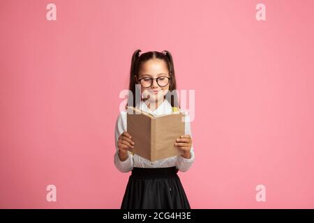 Stile di vita e tempo libero. Felice studentessa con occhiali legge libro Foto Stock