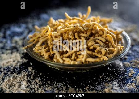 Primo piano di Gujarati famoso piatto da tè Bhavnagiri gathiya in un piatto da portata. Colpo di thikkha bhavnagari gathiya preparato di fresco in a s. Foto Stock