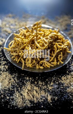 Primo piano di Gujarati famoso piatto da tè Bhavnagiri gathiya in un piatto da portata. Colpo di thikkha bhavnagari gathiya preparato di fresco in a s. Foto Stock