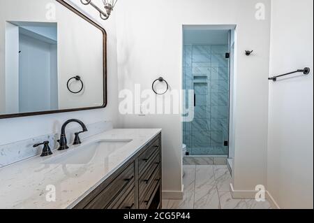 Bagno appena ristrutturato con doccia, wc, specchio, rubinetto e lavello Foto Stock
