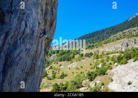 Scalatore di roccia su ripida scogliera ombreggiata con cielo blu, Rocher de Amoureux, Modane, Maurienne, Parco Nazionale della Vanoise, Francia Foto Stock