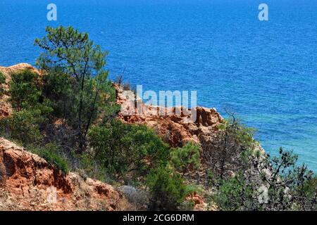 Scogliera colorata di rocce calcaree e l'Oceano Atlantico, Olhos de Agua, Algarve, Portogallo Foto Stock