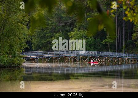 Kayak scivola lungo il ponte pedonale al tramonto sul lago Fort Yargo al Fort Yargo state Park di Winder, Georgia. (STATI UNITI) Foto Stock