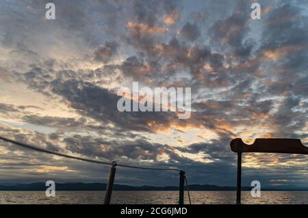 Tramonto nuvoloso sul lago Champlain visto da una storica vela goletta Foto Stock