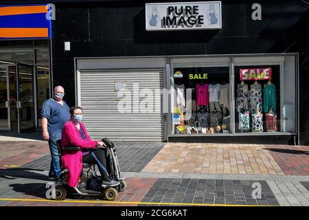 La gente indossa maschere sulla strada alta a Merthyr Tydfil, Galles, Quale potrebbe essere la prossima area in Galles per vedere un blocco locale come l'ex capo di analisi sanitaria presso l'Ufficio per le statistiche nazionali ha evidenziato la percentuale crescente di test Covid-19 positivi nella zona, con il 4.4% dei test in e intorno Merthyr test positivi. Foto Stock