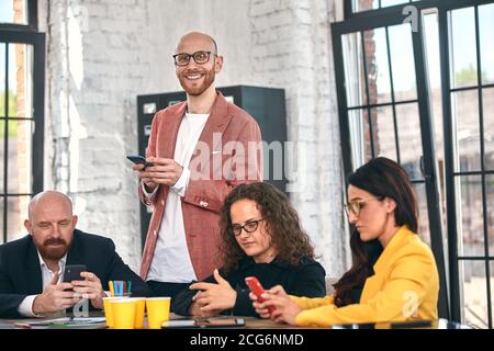 Inquadratura di un gruppo di giovani professionisti di aziende aventi una riunione. Diversi gruppi di giovani designer sorridente durante una riunione presso l'ufficio. Foto Stock