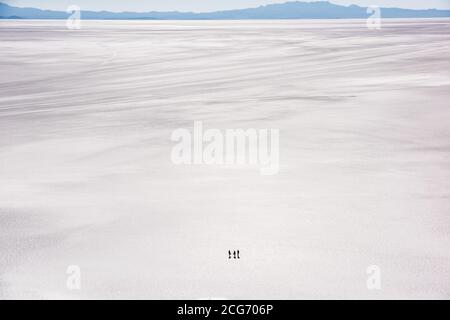 Vista aerea di tre turisti che attraversano la piana di sale di Uyuni, Altiplano, Bolivia Foto Stock