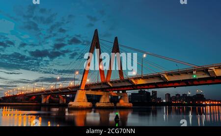 Il ponte di Millenium a Kazan, si riflette nelle acque del fiume Kazanka. Il ponte sul fiume è stato attraversato da un cavo. Il ponte con illuminazione notturna. Foto Stock