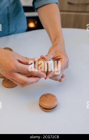 Donna che fa macaroni di cioccolato Foto Stock