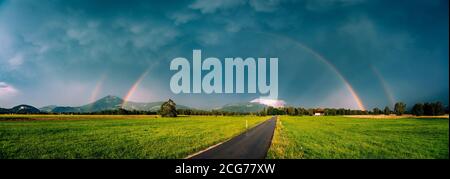Doppio arcobaleno su una strada attraverso il paesaggio rurale, Salisburgo, Austria Foto Stock