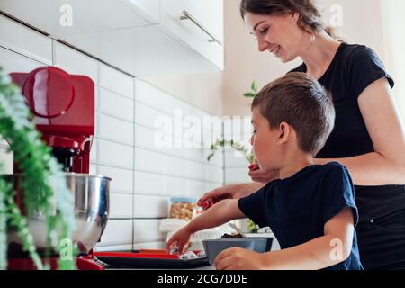 Chef pasticceria mamma e figlio cuoco dolci torte nel cucina Foto Stock