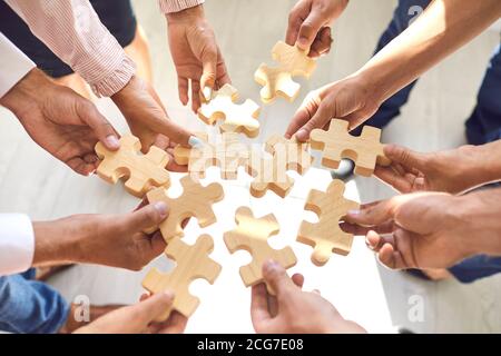 I dipendenti dell'azienda giocano a giocare e si uniscono a pezzi di puzzle durante l'attività di team building Foto Stock