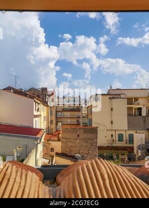Vista dal tetto in tegole rosse su un cortile chiuso accogliente circondato da edificio scolastico e vecchie case tradizionali in colori sabbiosi con terrazze e balconi. Foto Stock