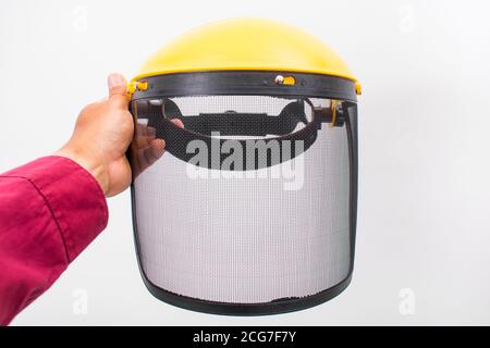 Una maschera protettiva gialla rasaerba su fondo bianco a mano Foto Stock