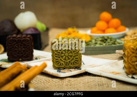 Festa di metà autunno torta di luna, cibo colorato e bevande su sfondo burlap. Viaggi. Vacanza, concetto di cibo Foto Stock