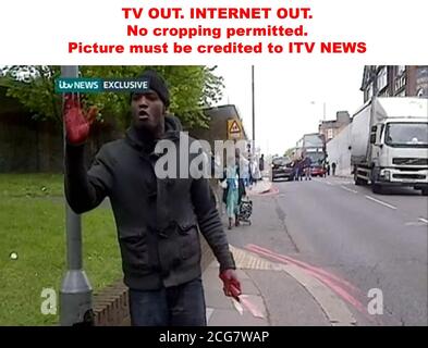 USCITA TV. INTERNET OUT.PLEASE ATTENZIONE CREDITO OBBLIGATORIO RICHIESTO: ITV NEWS/PA. NON È CONSENTITO RITAGLIARE IL LOGO. Video grab preso da ITV News di un uomo che detiene armi dalla scena in John Wilson Street, Woolwich dove un uomo è stato trovato assassinato. Foto Stock