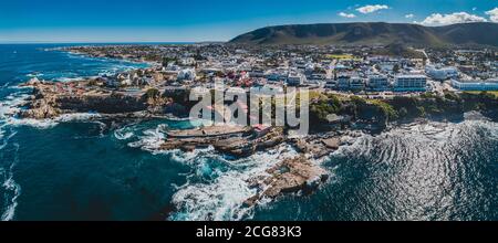 Foto aerea di Hermanus Old Harbour, accoccolato tra oceano e montagna Foto Stock