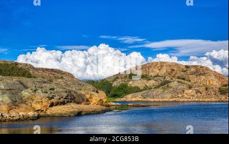 Una tranquilla vista costiera in Svezia con le nuvole di Cumulus Foto Stock