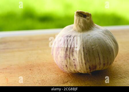 Bel primo piano di aglio su un tagliere di legno Foto Stock