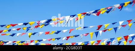 bandiere arcobaleno multicolore sul cielo blu per festeggiare. Bandiere colori cielo blu Foto Stock