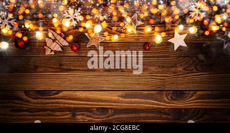 Sfondo di natale con decorazioni in legno e le luci spot. Spazio libero per il testo. Celebrazione e design decorativo. Foto Stock