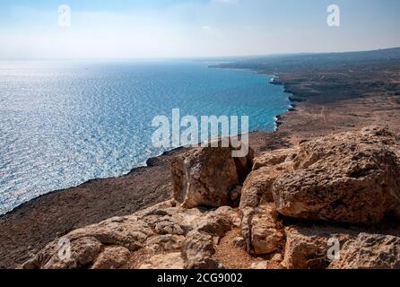 Guardando ad ovest sulla costa arida e rocciosa e il mare da Capo Greco, nel sud-est di Cipro. Foto Stock