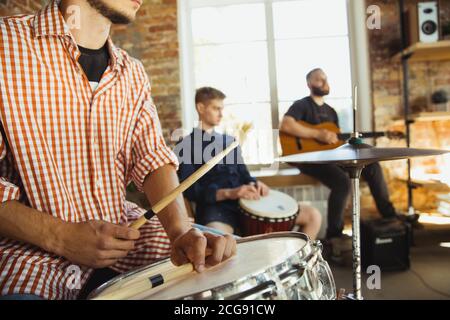 Ritmo. Band musicista jamming insieme in un posto di lavoro d'arte con strumenti. Uomini e donne caucasici, musicisti, suonando e cantando insieme. Concetto di musica, hobby, emozioni, occupazione artistica. Foto Stock