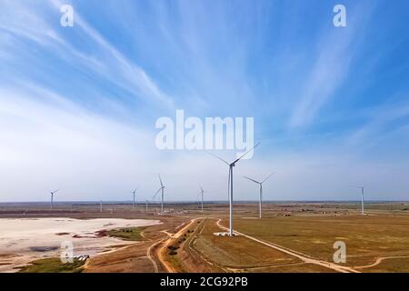 Turbine eoliche che producono energia verde alternativa contro il cielo blu Foto Stock