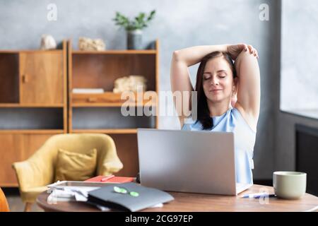 La donna di affari allunga il suo corpo facendo l'esercitazione di yoga alla rottura del caffè. Foto Stock