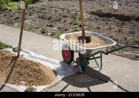 Carrello da giardino in metallo con sabbia e pala in costruzione sito Foto Stock