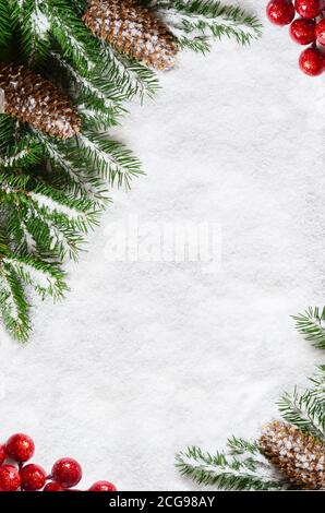 Sfondo di natale, verde rami di pino, coni sulla neve sullo sfondo. Composizione creativa di frontiera e di spazio copia, vista dall'alto. Anno nuovo, vacanze, c Foto Stock
