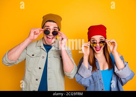 Foto di due simpatiche e positive persone sbalordite che decollo occhiali isolati sfondo giallo estivo Foto Stock