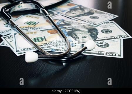 Stethoscope sulle fatture di cento dollari vicino in su Foto Stock